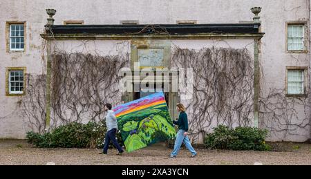 Artist Joe Grieve with one of his large colourful paintings at the first art exhibition at Colstoun House, East Lothian, Scotland, UK Stock Photo