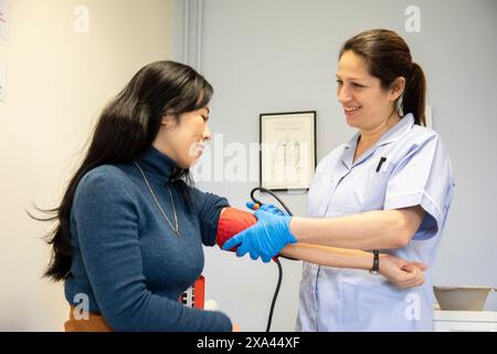 Nurse taking patient's blood pressure Stock Photo