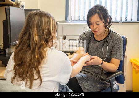 Nurse preparing to administering a vaccine to a patient Stock Photo
