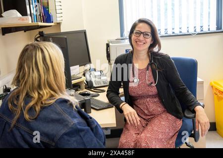 Doctor in glasses smiling with patient in medical practice Stock Photo
