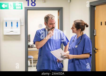 Medical professionals having a discussion in a hospital corridor, medical practice UK Stock Photo