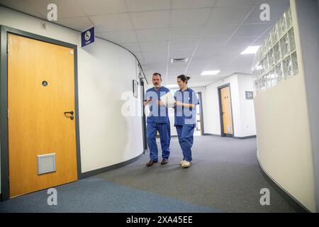 Two healthcare professionals walking in a hospital corridor, medical practice UK Stock Photo