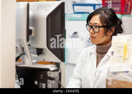 Scientist working at a computer in a lab, medical practice UK Stock Photo