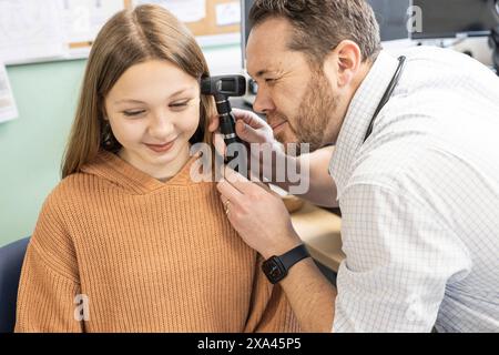 Doctor examining a young girl's ear with an otoscope Stock Photo