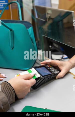 Woman making a contactless payment at a reception desk of a medical practice Stock Photo