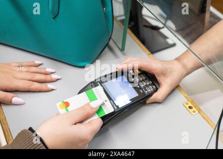 Woman making a contactless payment at a reception desk of a medical practice Stock Photo