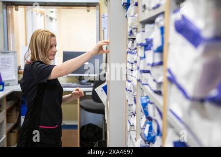 Nurse retrieving a file from a hospital storage system Stock Photo