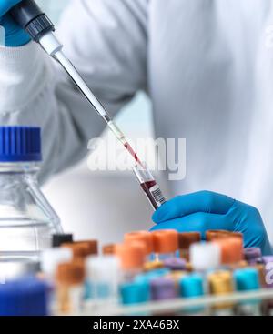 Scientist pipetting blood sample in laboratory Stock Photo
