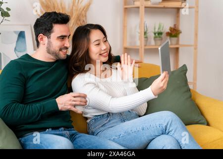 Couple taking a selfie on a yellow couch. Stock Photo
