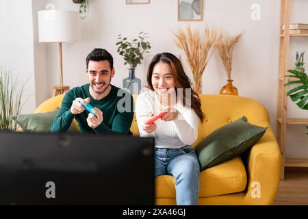 Two people playing video games on a couch. Stock Photo