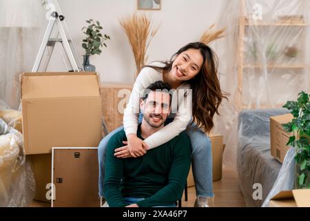 Couple embracing amid moving boxes in new home. Stock Photo