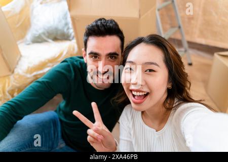 Couple smiling and taking a selfie during a moving day. Stock Photo