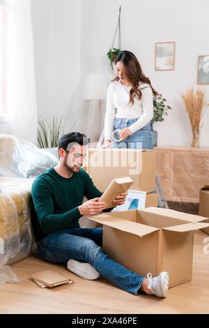 Couple unpacking boxes in a new home. Stock Photo