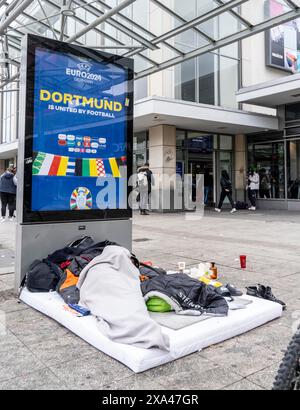 Homeless man sleeping in front of the entrance of Dortmund Central Station, NRW, Germany, Stock Photo