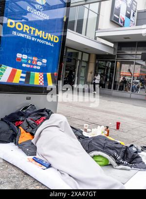 Homeless man sleeping in front of the entrance of Dortmund Central Station, NRW, Germany, Stock Photo