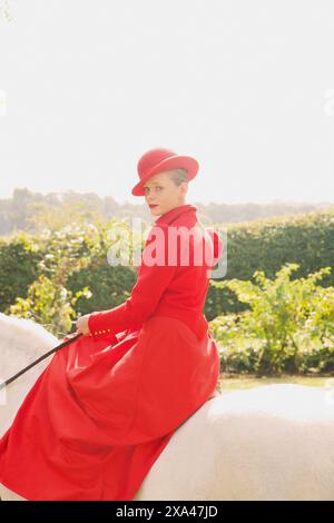 Woman in Red Equestrian Outfit Sidesaddle Riding Stock Photo