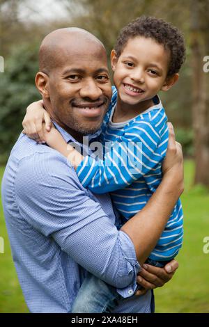 Father and Young Son Hugging Outdoors Stock Photo