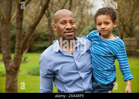 Father Holding Young Son Outdoors Stock Photo