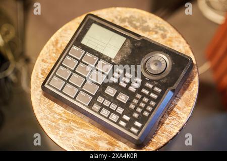 An old-fashioned calculator with large buttons and a small screen, displayed on a wooden table. Stock Photo