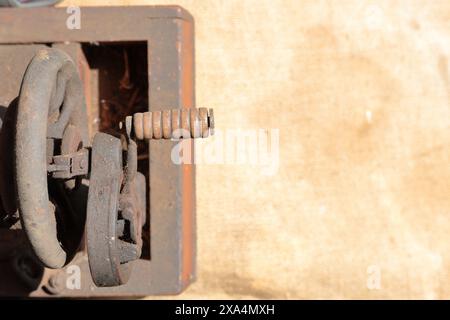 Old sewing machine, with manual drive. Covered with corrosion, dust and cobwebs. It stands on a coarse cloth. Stock Photo