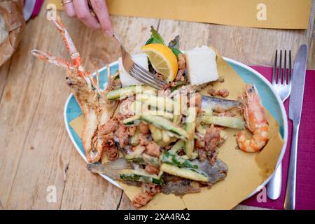 Fresh seafood platter with zucchini and lemon on a vibrant plate. Stock Photo