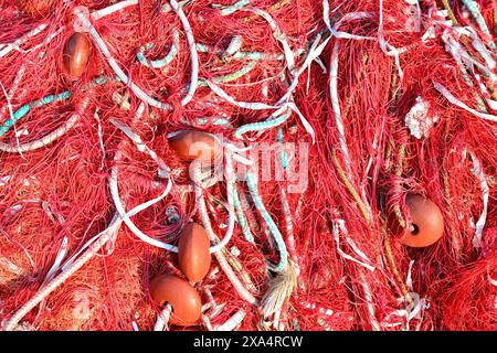 Red fishing net, orange floats and ropes in daytime. Stock Photo