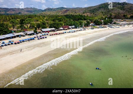 Aerial view of waves breaking onto a sandy tropical beach in Lombok Stock Photo