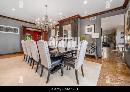 Spacious home interior with connected dining and living areas, featuring cozy carpet flooring Stock Photo