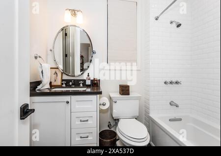 Modern bathroom with white tub, toilet, sink, and mirror Stock Photo