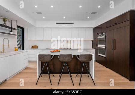 A roomy kitchen with two bar stools at the breakfast bar Stock Photo