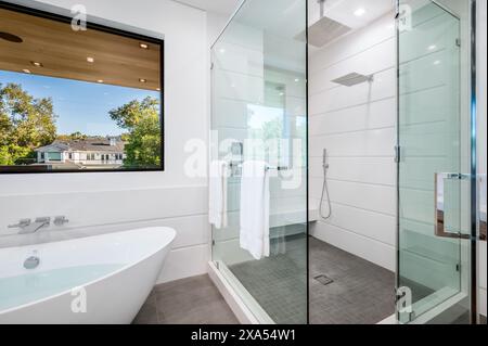 A modern bathroom featuring a sink and walk-in shower Stock Photo