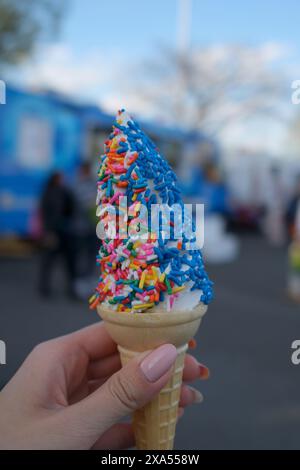 An kice cream cone topped with colorful sprinkles and a chocolate candy bar Stock Photo