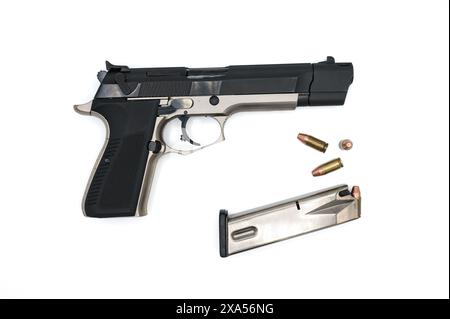 Detail of a nice police pistol with the magazine and some 9 mm bullets with a truncated cone tip on a white background. Stock Photo