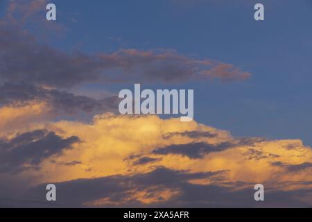 photo of a golden and dark clouds on a sunset, dramatic evening blue sky background Stock Photo