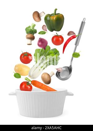 Fresh ingredients falling into saucepan on white background Stock Photo