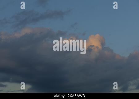 photo of an evening sky with large dark and yellow clouds on sunset Stock Photo