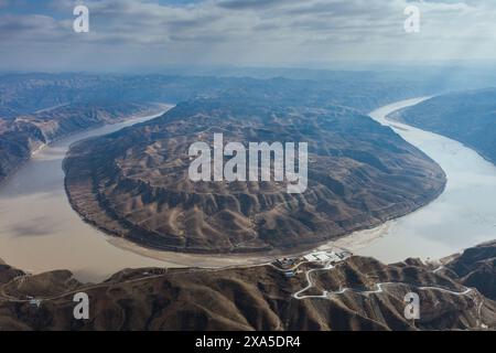 Aerial view of a winding river flowing through lush green agricultural ...