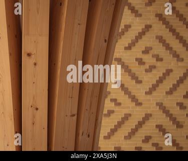Interior detail of timber column with patterned tile detail in background. Cambridge Mosque, Cambridge, United Kingdom. Architect: Marks Barfield Arch Stock Photo