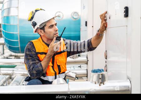 A technical foreman chatting on radio about building systems maintenance in Thailand, Bangkok Stock Photo