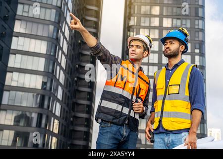The two construction workers in hard hats at a construction site in Thailand, Bangkok Stock Photo