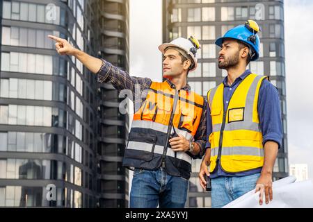 The two construction workers in hard hats at a construction site in Thailand, Bangkok Stock Photo