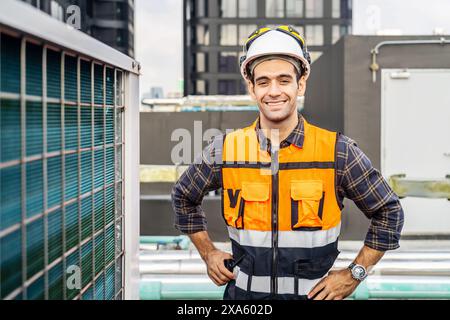 A happy construction worker in orange safety gear and hardhat at a construction site in Thailand, Bangkok Stock Photo