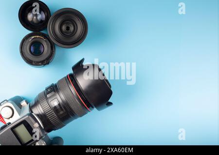 A camera and lenses on a blue background. Stock Photo