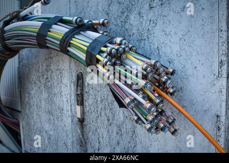 A close-up of multiple wires connected to a wall Stock Photo