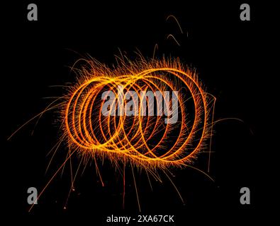 Vibrant orange swirl with letter o inside, against black backdrop Stock Photo