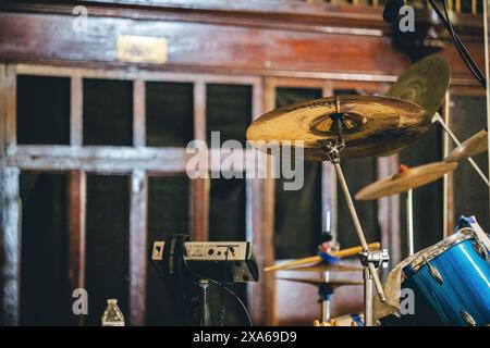 Professional acoustic guitar placed on the ground next to drums Stock Photo