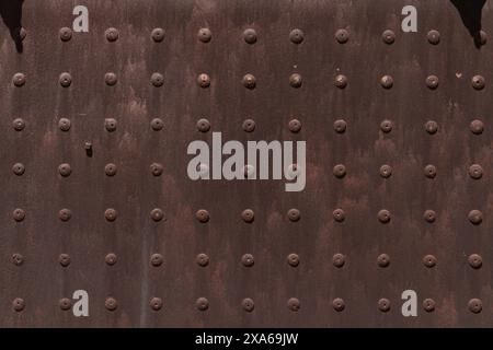 A metal texture on a building wall with multiple holes Stock Photo