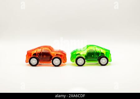 The two toy cars placed side by side on a white background. Stock Photo