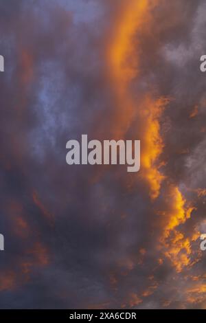 photo of an evening sunset sky with golden and purple cumulus and perispheric clouds Stock Photo