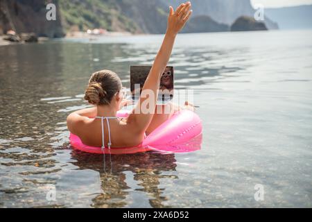 Freelance close up woman hands writing on computer. Well looking middle aged woman typing on laptop keyboard outdoors with beautiful sea view. Stock Photo